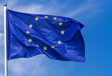 Flag Of The European Union Waving In The Wind On Flagpole Against The Sky With Clouds, Banner