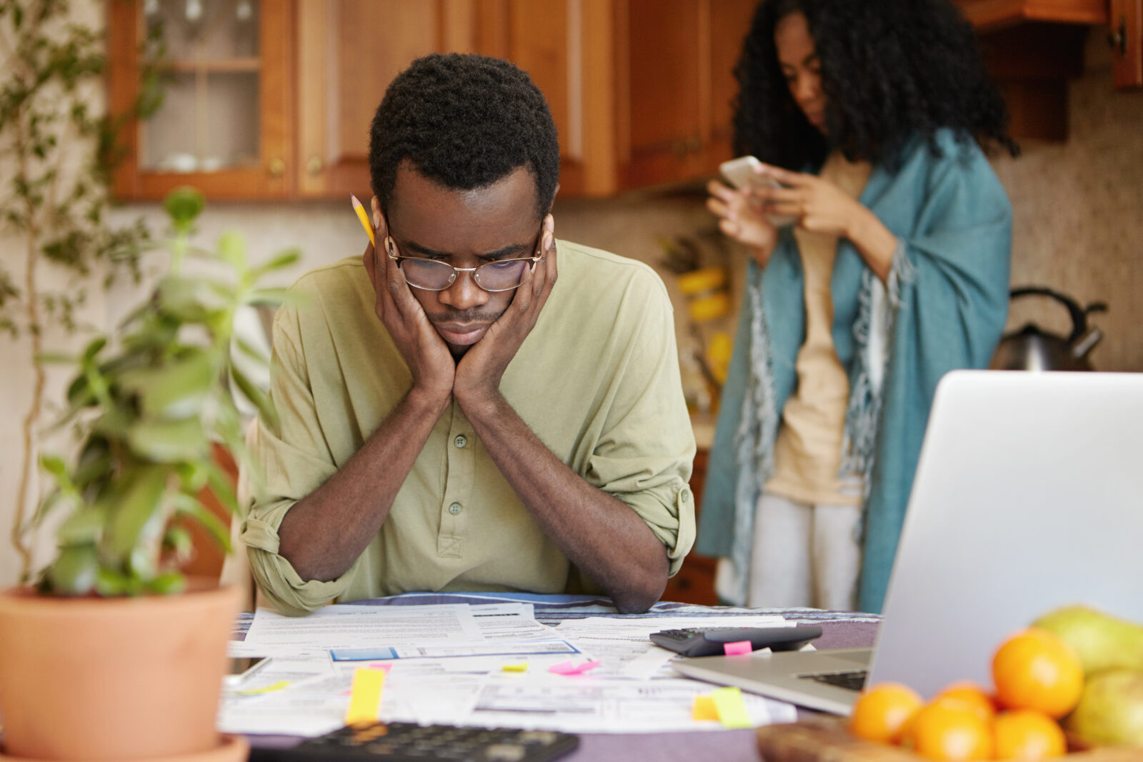 Stressed Young African Male Doing Paperwork At Home, Holding Hands On Head Having Frustrated And Puzzled Look While Reading Notification From Bank In Front Of Him, Failed To Pay Loan In Time